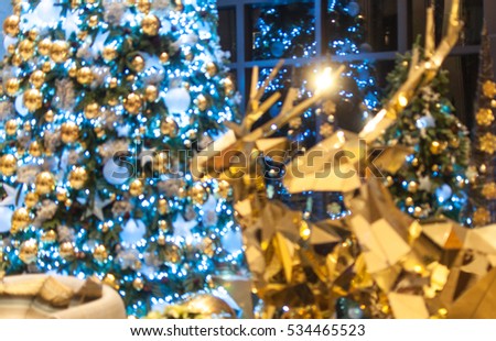 Bokeh background of Christmas tree and golden reindeer. Blurred background. Christmas theme. Royalty-Free Stock Photo #534465523