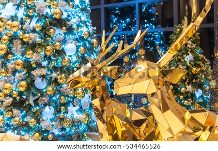 Golden Reindeer and blurred lighted Christmas tree in the background. Merry Christmas.