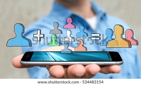 Businessman on blurred background using hand drawn social network with his mobile