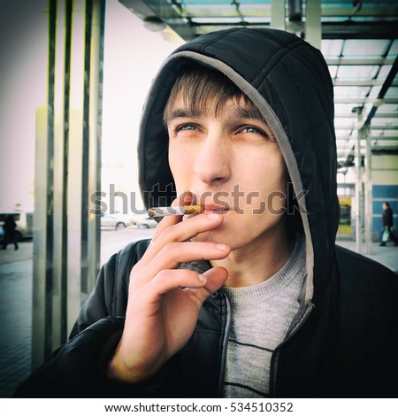 Toned Photo of Young Man with Cigarette at the City Street