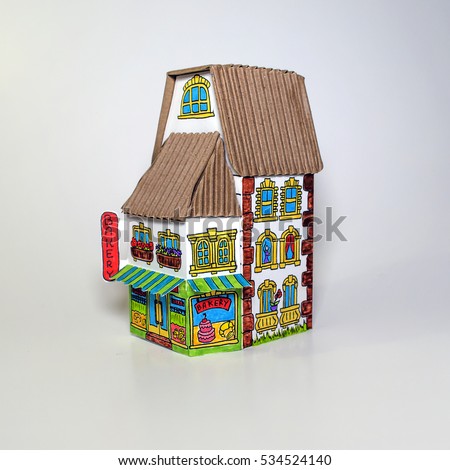 Model cardboard house. Funny doodle house. The building of the bakery. The concept, the house from the goffered cardboard, isolated on a white background. Vintage style.