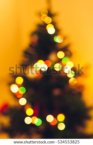 Blurred lights and christmas tree. Decorating home for holidays. Warm and cozy photo with pine tree, garland and christmas lights