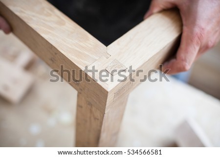 Detail of a furniture maker holding an example of his intricate Japanese joinery Royalty-Free Stock Photo #534566581