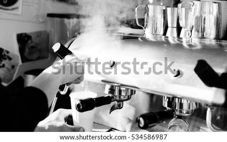 Black and white picture of professional coffee machine in restaurant. Closeup of metal equipment coffee cup indoor background.