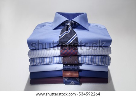 Folded Man's shirts and ties isolated on white background.