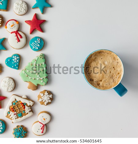 Colorful pattern made of Christmas cookies and red berries with coffee cup. Flat lay holiday concept.