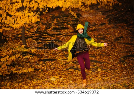 beautiful young woman jumping outdoors in autumn