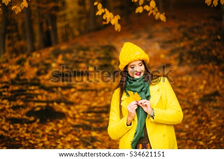 Happy girl in coat  with maple yellow leaves, autumn time