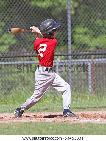 Full view of a young baseball player taking a major league swing at the ball.