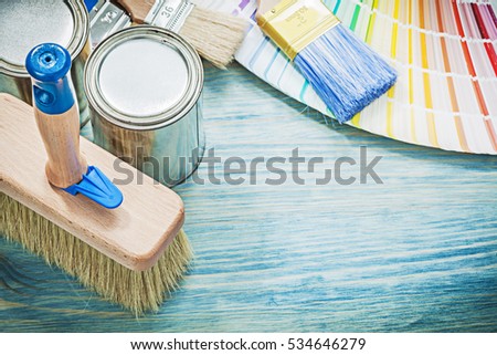 Paint cans brushes pantone fan on wooden board construction concept.