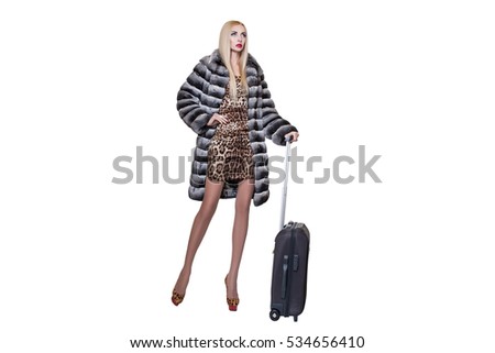 woman in a full-length fur coat with a suitcase, Trips and recreation, tourism. girl and a suitcase. beautiful female tourist with travel suitcase, isolated on white. girl and a suitcase 