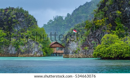 Bamboo Hut between some Rocks under Rain in Bay, Painemo Islands, Raja Ampat, West Papua, Indonesia Royalty-Free Stock Photo #534663076