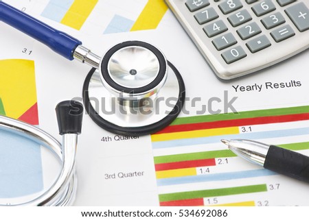 Medical practice financial analysis charts with stethoscope and calculator.