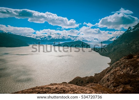 Photo of sea and mountains covered with snow in Parque Nacional Torres del Paine in Chile.