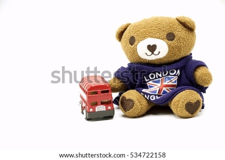Teddy Bear with red double desk London bus are on white background.