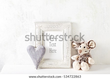 An arrangement of a mascot, wooden heart and a picture frame