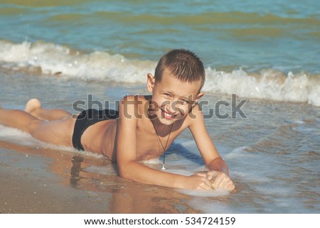 Happy Children - little boy having fun on the beach. Positive human emotions.