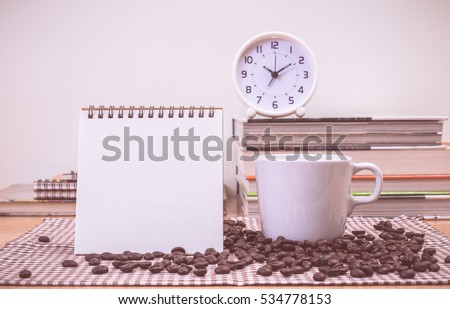 Coffee cup Clock and blank calendar on table. vintage color effected