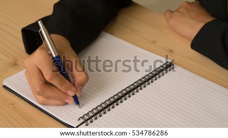 woman holding a pen and filling business plan
