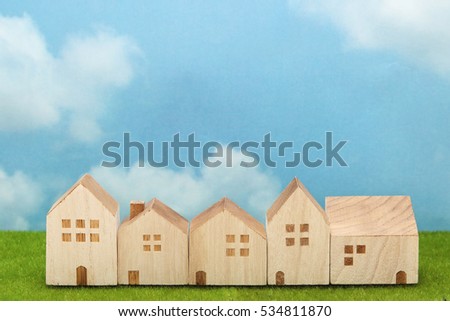 Houses on green grass over blue sky. Mortgage concept.