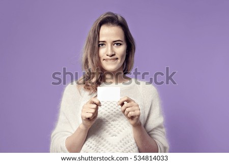 Close-up portrait of european young smiling business woman holding credit card. isolated on color background
