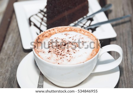 chocolate cake with coffe on plate on wood table
