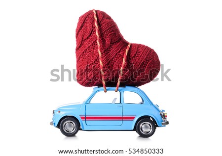 Blue retro toy car delivering heart for Valentine's day on white background