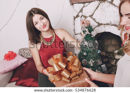 Girl decorate the Christmas tree. give gifts. pictures. good time