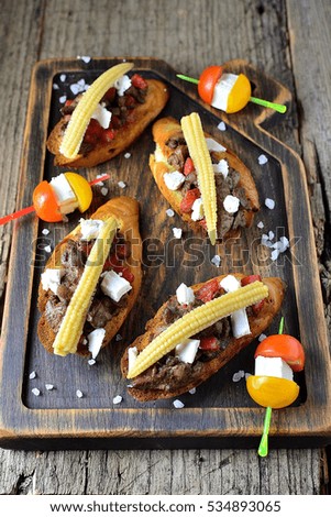 liver bruschetta, cheese and corn on the wooden background