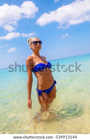 Young slim blonde swimming in the sea outdoors