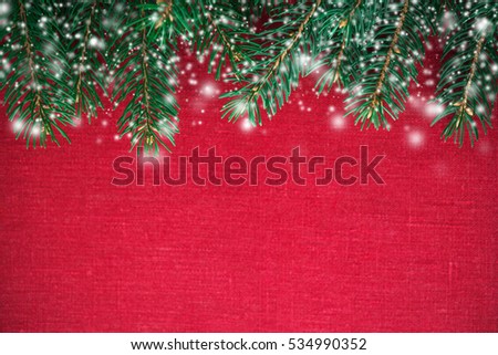 Christmas background with xmas tree and snow on red canvas background. Merry christmas greeting card, frame, banner. Winter holiday theme. Happy New Year. Space for text.