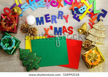 Christmas decorations with colorful square note papers on a wooden background