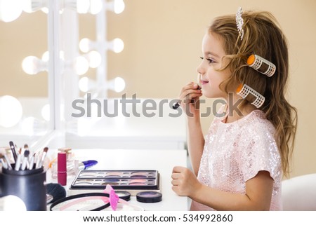 beautiful little girl in the mirror preening. little beauty