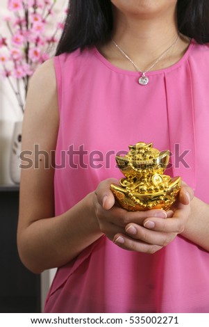Lady holing mock gold ingot as a sign of prosperity