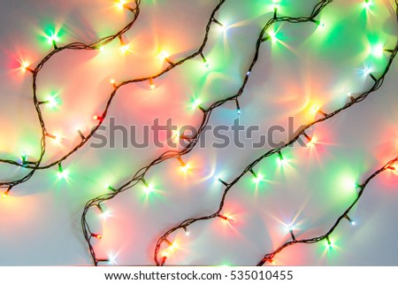Christmas romantic lights frame on white background with copy space. Decorative garland in clean space. Clear perfect beautiful decoration for intimate evening dinner. Studio close up photo. Seamless.