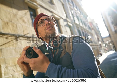 Hipster guy taking pictures in european city 
