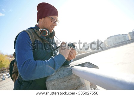 Hipster man taking pictures by the sea