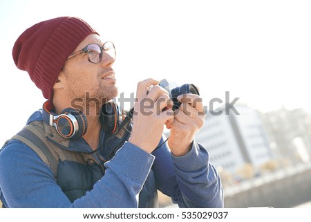 Hipster man taking pictures by the sea