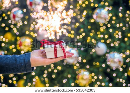 Man holding a gift in his hands. Man holding a gift box. People celebrating xmas, love and happiness concept - cool young man holding present white gift box in hand