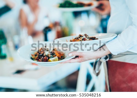 Serving food in restaurant Royalty-Free Stock Photo #535048216