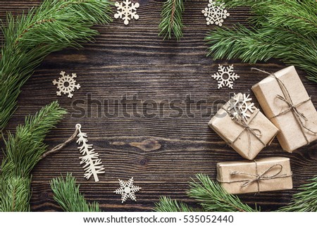 Christmas background with fir branches, wooden decorations and gift boxes. Space for text. Top view.