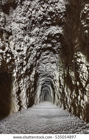The tunnel is an artificial passage built through a limestone mountain.