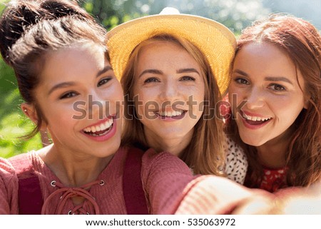 leisure, holidays and people concept - happy women or friends taking selfie at summer