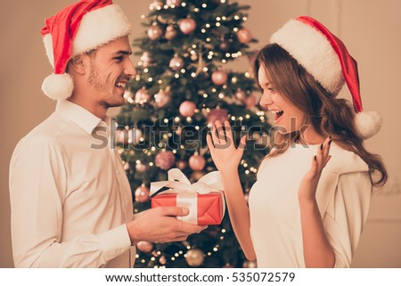 Excited happy woman receiving xmas present from her boyfriend