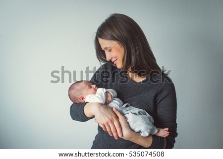 A woman holding a newborn. Mom and baby. Close-up. Royalty-Free Stock Photo #535074508