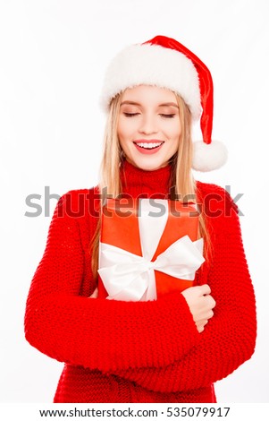 Young happy woman holding box and dreaming about xmas gift