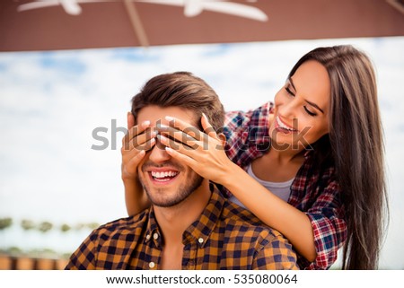 Young smiling woman closing eyes of her boyfriend in cafe Royalty-Free Stock Photo #535080064