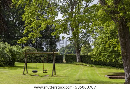 Image of childrens swing set in green park.  Royalty-Free Stock Photo #535080709