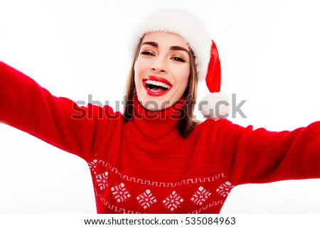 Happy laughing pretty woman in santa hat making selfie