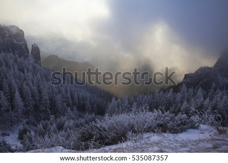 Fantastic dawn winter landscape with dramatic sunrise, fog and snow